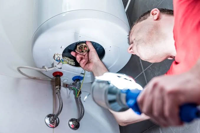 Emergency water heater repair technician working on a failed tank in Lancaster, PA