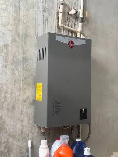 Wall-mounted Rheem tankless water heater on a concrete wall